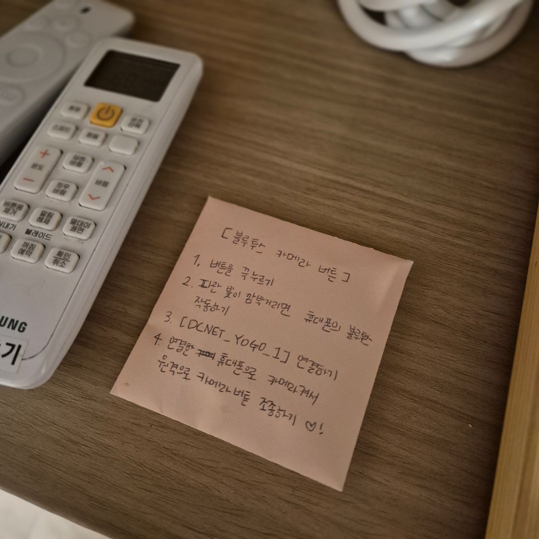 이용 안내가 적힌 손글씨 메모와 리모컨